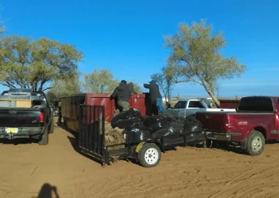 Crew loading trash bags into dumpster at Meadowlake cleanup